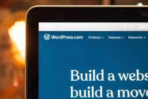 A laptop screen displaying the WordPress.com website with menu options: Products, Features, and Resources.