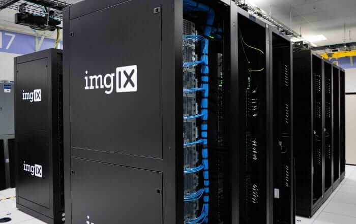 A row of black server racks with visible cabling in a data center.