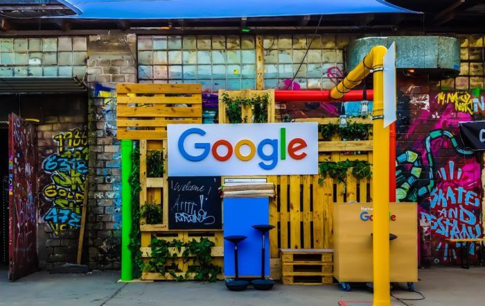 Colorful Google display with a wooden backdrop, surrounded by graffiti-covered walls.