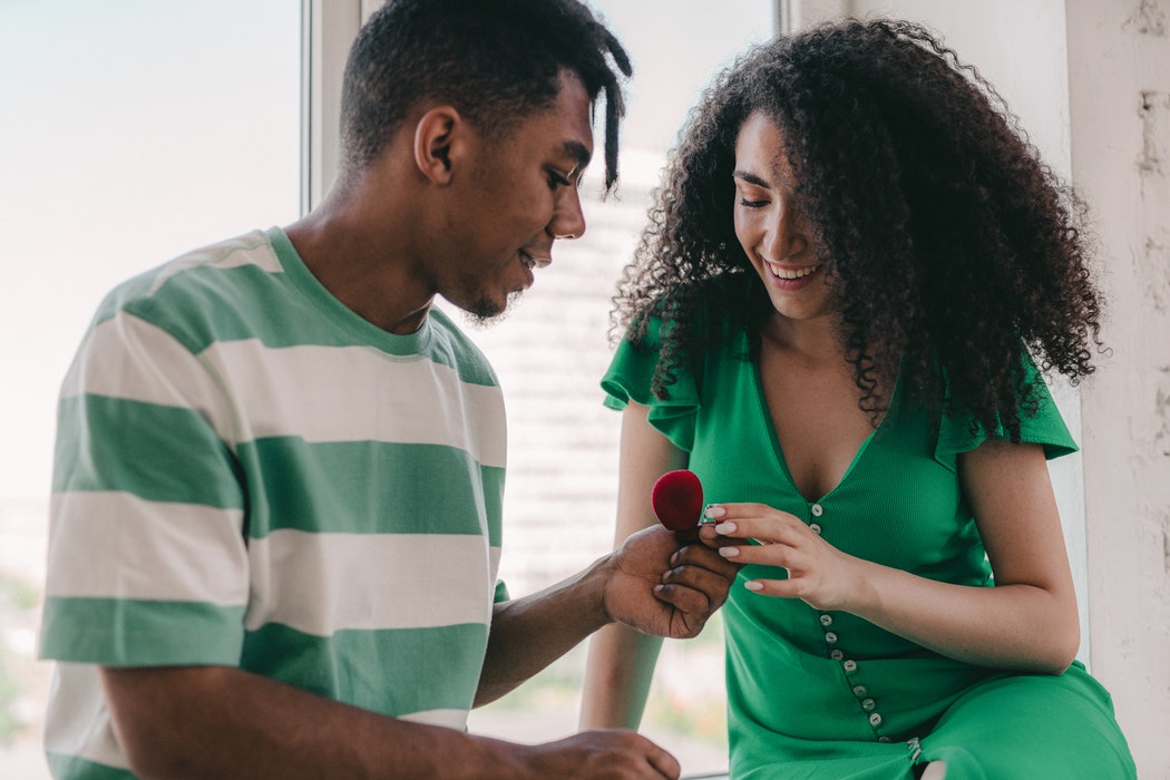 young man present engagement ring to young woman